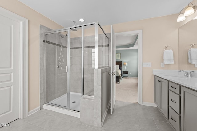 bathroom with baseboards, a stall shower, tile patterned floors, and vanity