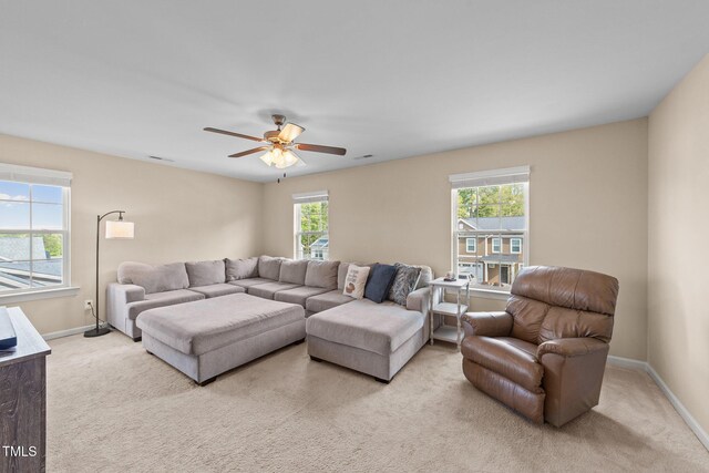 carpeted living area featuring baseboards and ceiling fan