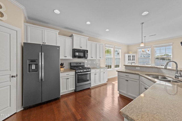 kitchen featuring stainless steel appliances, a sink, ornamental molding, white cabinets, and dark wood-style floors