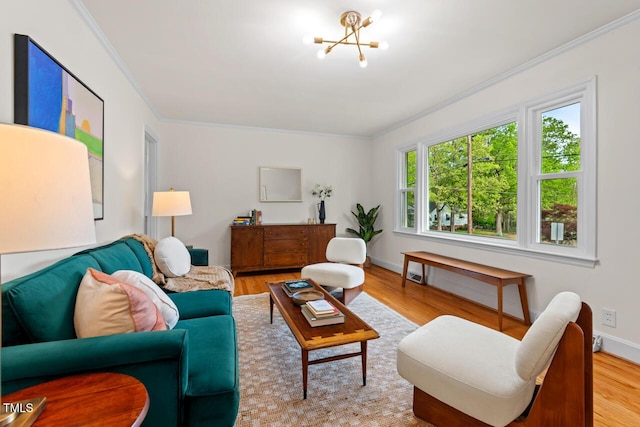 living area with an inviting chandelier, baseboards, ornamental molding, and wood finished floors