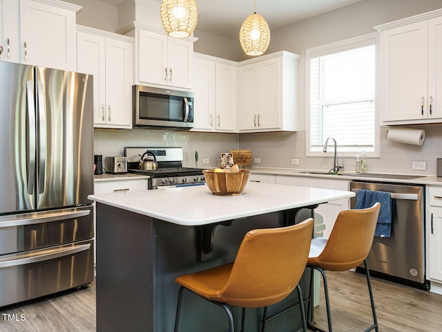 140 Clear Water Rd, Louisburg, NC 27549 - kitchen featuring tasteful backsplash, white cabinets, a kitchen island, appliances with stainless steel finishes, and light countertops