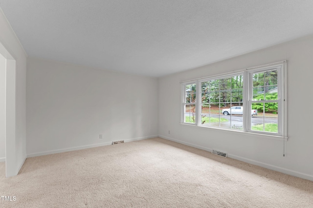 spare room featuring visible vents, baseboards, and carpet flooring