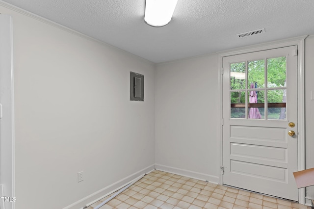 empty room with baseboards, ornamental molding, electric panel, a textured ceiling, and visible vents