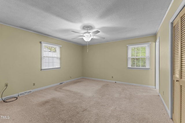 unfurnished bedroom with carpet flooring, visible vents, and ornamental molding