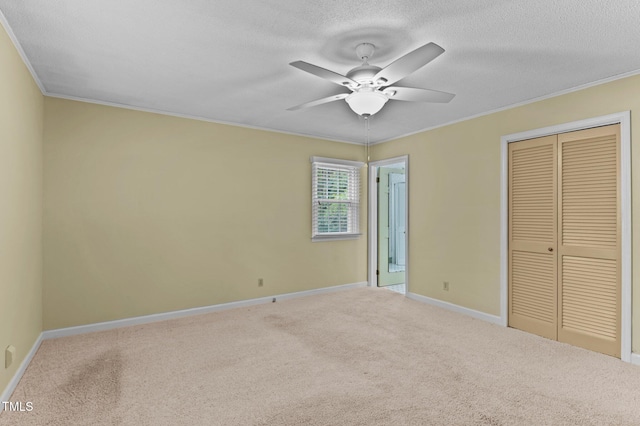 unfurnished bedroom with a closet, carpet flooring, baseboards, and ornamental molding