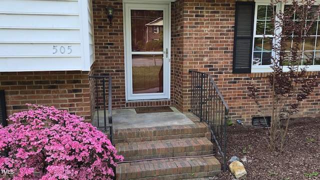 view of exterior entry with brick siding