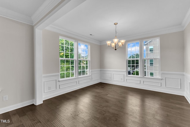 unfurnished dining area featuring a chandelier, a wainscoted wall, dark wood-style floors, and ornamental molding