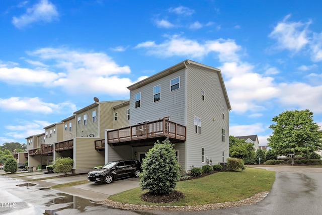 rear view of property featuring a residential view, central AC, and a yard