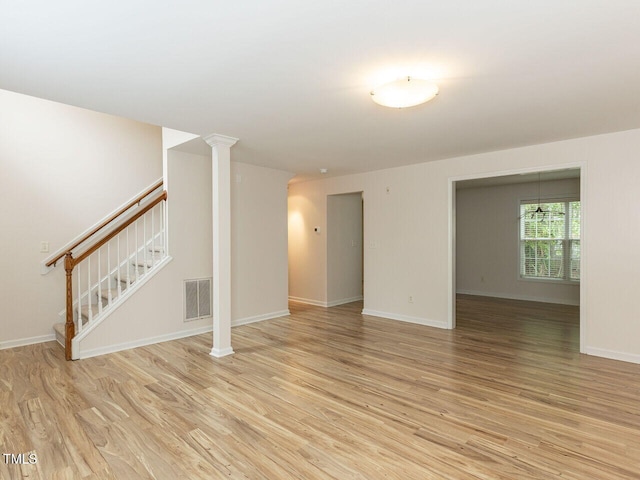 unfurnished living room featuring stairway, baseboards, light wood-style floors, and visible vents