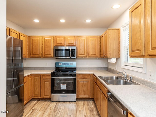 kitchen with recessed lighting, appliances with stainless steel finishes, a sink, and light countertops