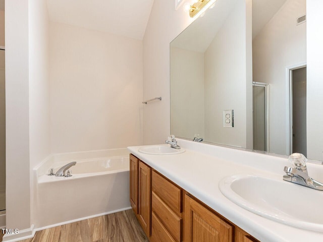 bathroom with a shower stall, a garden tub, a sink, and double vanity
