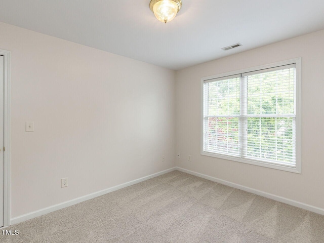 unfurnished room featuring light colored carpet, baseboards, and visible vents