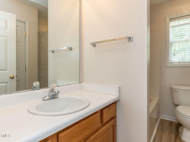 full bath featuring wood finished floors, toilet, vanity, a bathtub, and walk in shower