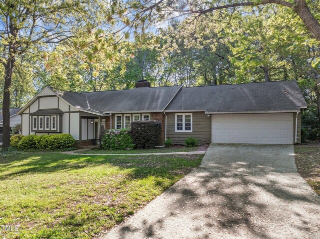 1304 Deboy St, Raleigh, NC 27606 - view of front of property with a front yard, brick siding, an attached garage, a chimney, and driveway