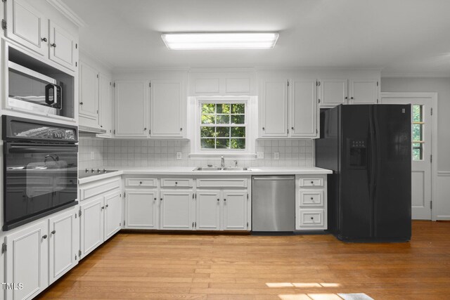 1304 Deboy St, Raleigh, NC 27606 - kitchen featuring a sink, light countertops, black appliances, and white cabinetry