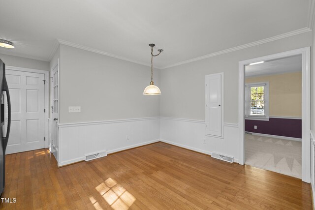 1304 Deboy St, Raleigh, NC 27606 - unfurnished dining area featuring hardwood / wood-style floors, baseboards, ornamental molding, and visible vents