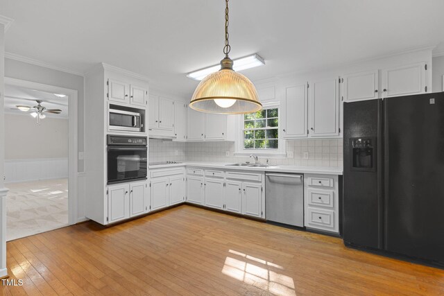 1304 Deboy St, Raleigh, NC 27606 - kitchen with white cabinets, a sink, light countertops, and black appliances