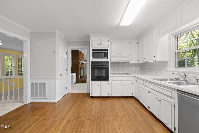1304 Deboy St, Raleigh, NC 27606 - kitchen featuring white cabinetry, light wood-style floors, visible vents, stainless steel appliances, and a sink