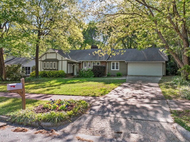 1304 Deboy St, Raleigh, NC 27606 - view of front facade with a chimney, a garage, a front yard, and driveway