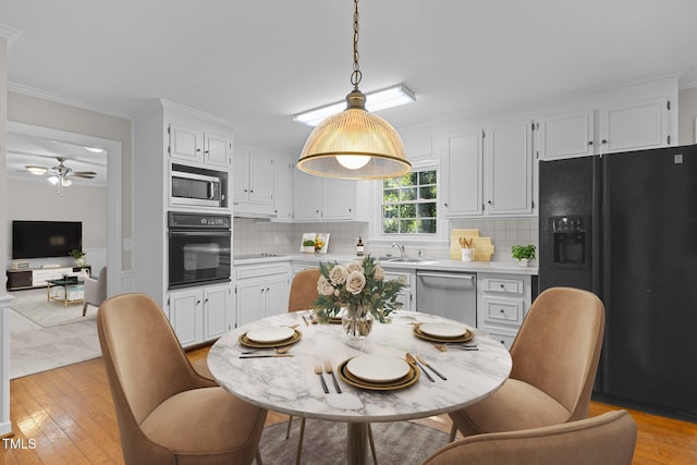 1304 Deboy St, Raleigh, NC 27606 - kitchen featuring white cabinets, light countertops, and black appliances