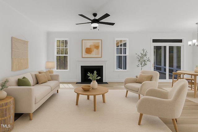 858 Lake Artesia Ln, Fuquay Varina, NC 27526 - living area featuring a ceiling fan, a fireplace with flush hearth, a chandelier, light wood-style flooring, and baseboards