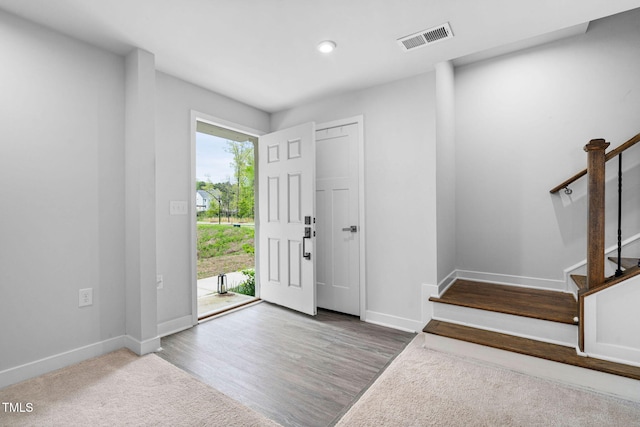 entrance foyer with stairway, wood finished floors, baseboards, visible vents, and recessed lighting