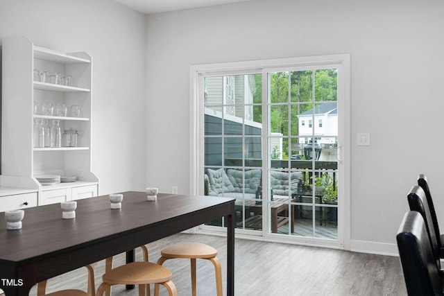dining area featuring baseboards and light wood-type flooring