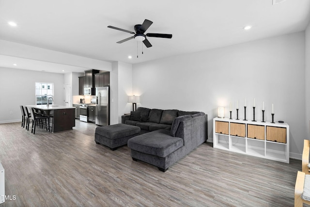 living area with ceiling fan, wood finished floors, and recessed lighting