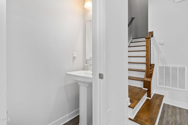 bathroom featuring baseboards, wood finished floors, and visible vents