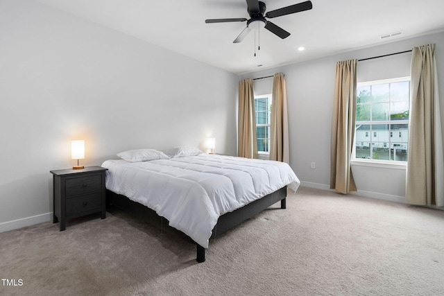 bedroom with light colored carpet, multiple windows, and visible vents