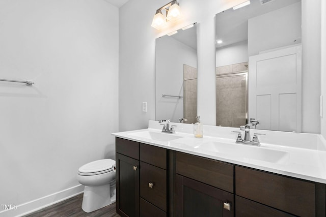bathroom featuring toilet, wood finished floors, a sink, and baseboards