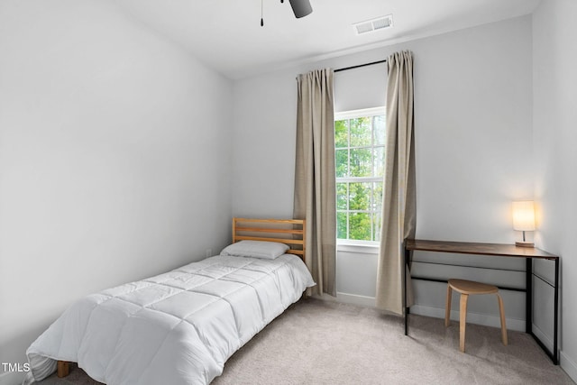 carpeted bedroom featuring baseboards, a ceiling fan, and visible vents