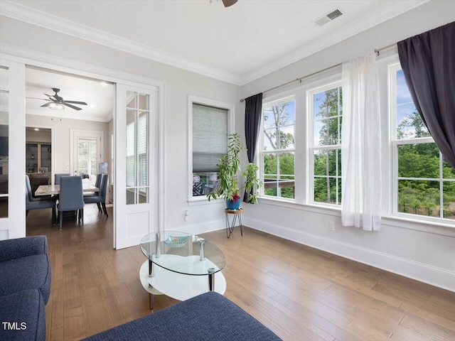 living area featuring ceiling fan, crown molding, hardwood / wood-style floors, and baseboards