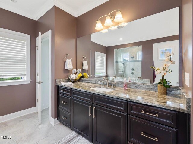 full bathroom featuring a tile shower, crown molding, vanity, and baseboards