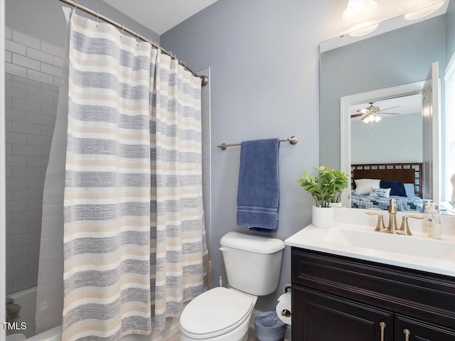 ensuite bathroom featuring toilet, vanity, ceiling fan, and shower / tub combo with curtain