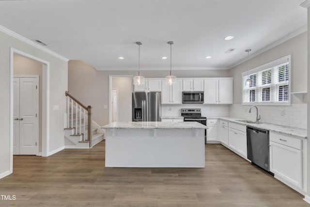 1077 Williams-White Rd, Zebulon, NC 27597 - kitchen with crown molding, white cabinets, a center island, a sink, and stainless steel appliances