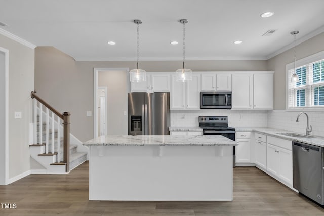 1077 Williams-White Rd, Zebulon, NC 27597 - kitchen featuring visible vents, a sink, ornamental molding, wood finished floors, and stainless steel appliances