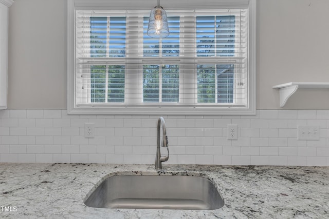1077 Williams-White Rd, Zebulon, NC 27597 - kitchen featuring tasteful backsplash, a healthy amount of sunlight, a sink, and light stone countertops
