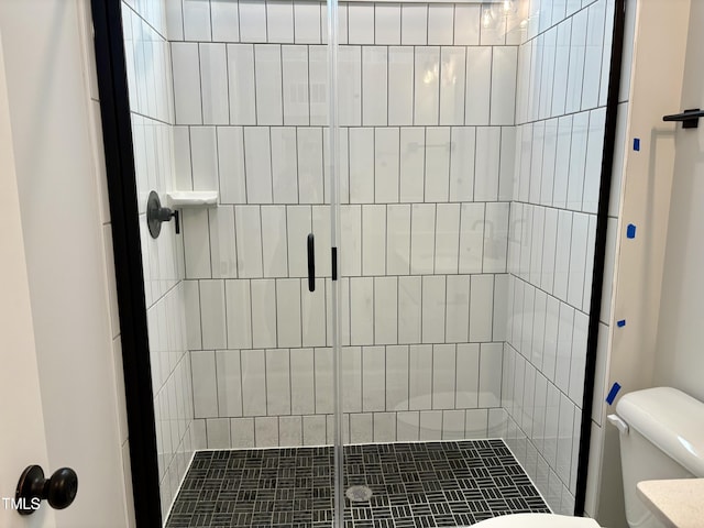 bathroom with a shower stall and toilet