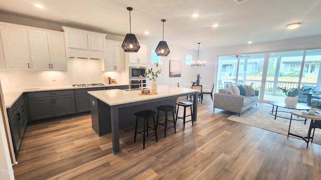 1237 Porters Call Dr, Wendell, NC 27591 - kitchen with stainless steel appliances, wood finished floors, recessed lighting, tasteful backsplash, and a breakfast bar area