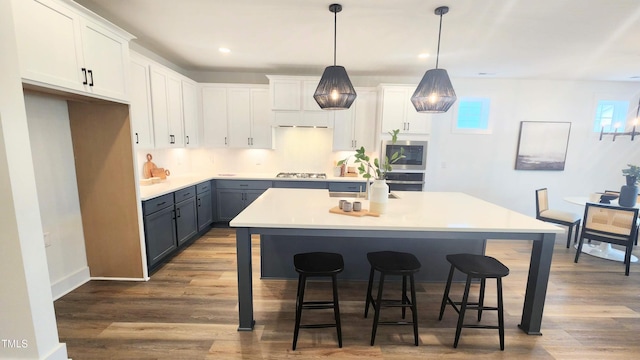 1237 Porters Call Dr, Wendell, NC 27591 - kitchen with white cabinets, stainless steel gas stovetop, a kitchen breakfast bar, and recessed lighting