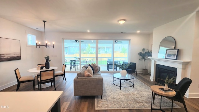 1237 Porters Call Dr, Wendell, NC 27591 - living area with dark wood-style flooring, a ceiling fan, a glass covered fireplace, a chandelier, and recessed lighting