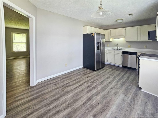 kitchen featuring visible vents, baseboards, a sink, appliances with stainless steel finishes, and dark wood-type flooring