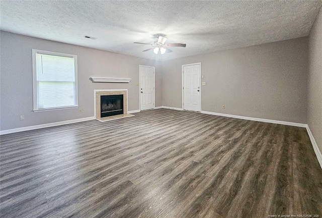 unfurnished living room featuring dark wood-type flooring, visible vents, baseboards, and a ceiling fan