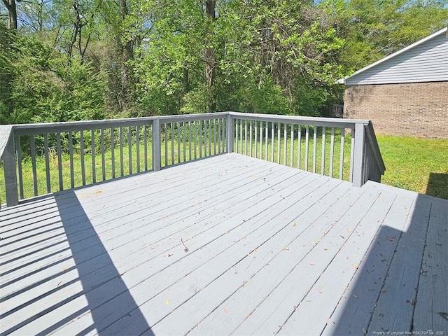 wooden terrace featuring a yard