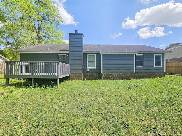 back of property featuring a yard, fence, a wooden deck, and a chimney