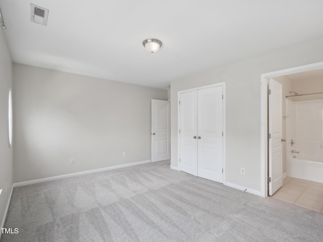 unfurnished bedroom featuring carpet flooring, baseboards, visible vents, and a closet