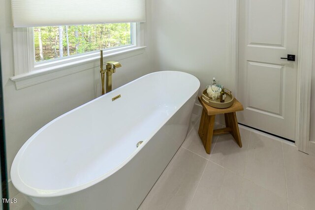 full bathroom featuring a freestanding bath and tile patterned floors