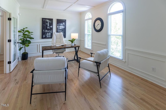 office area with a decorative wall, coffered ceiling, wainscoting, light wood-style floors, and beamed ceiling