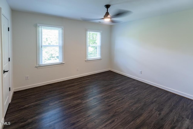 unfurnished room with ceiling fan, dark wood-style flooring, and baseboards